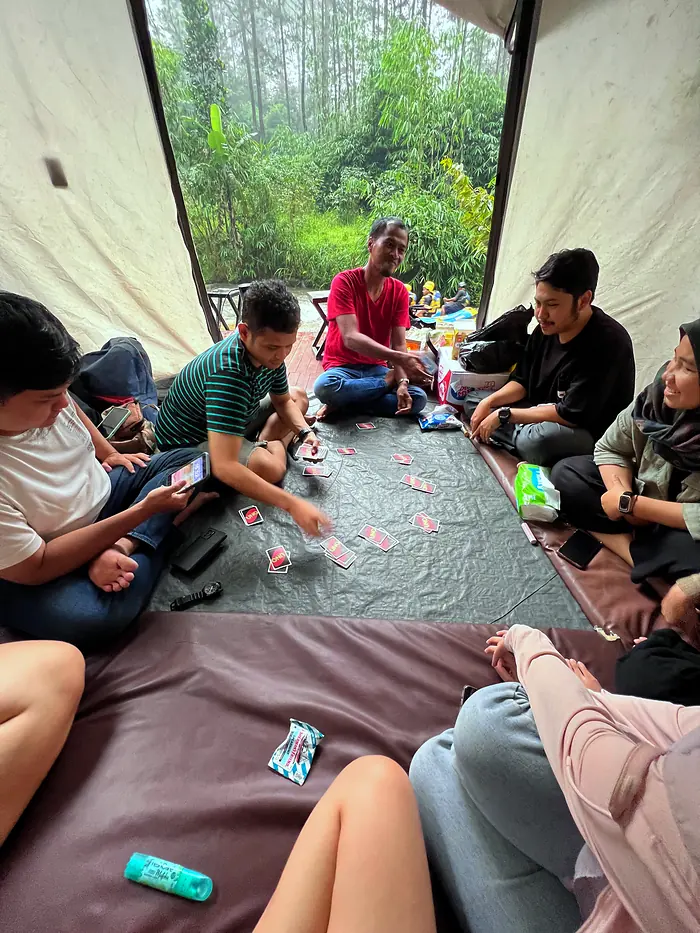 Tamu bermain kartu bersama di dalam tenda